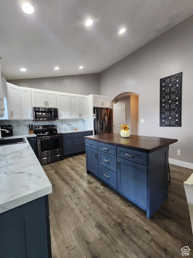kitchen featuring wooden counters, appliances with stainless steel finishes, backsplash, blue cabinetry, and white cabinetry