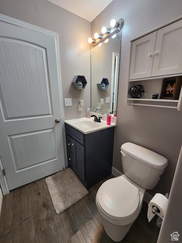 bathroom with vanity, hardwood / wood-style flooring, and toilet