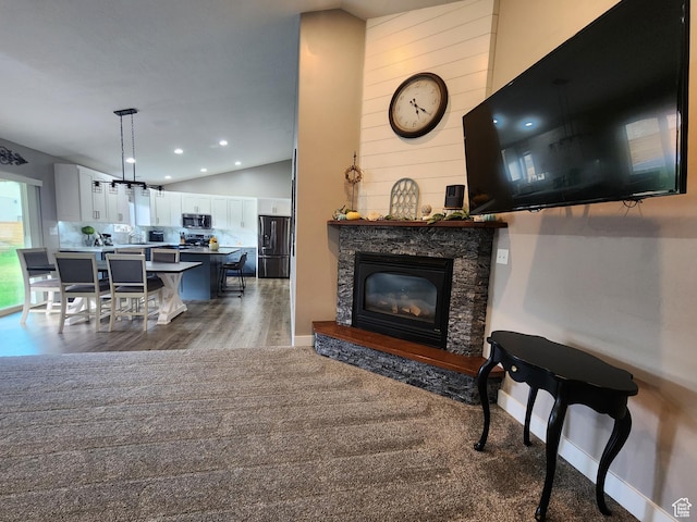 carpeted living room with sink, vaulted ceiling, and a premium fireplace