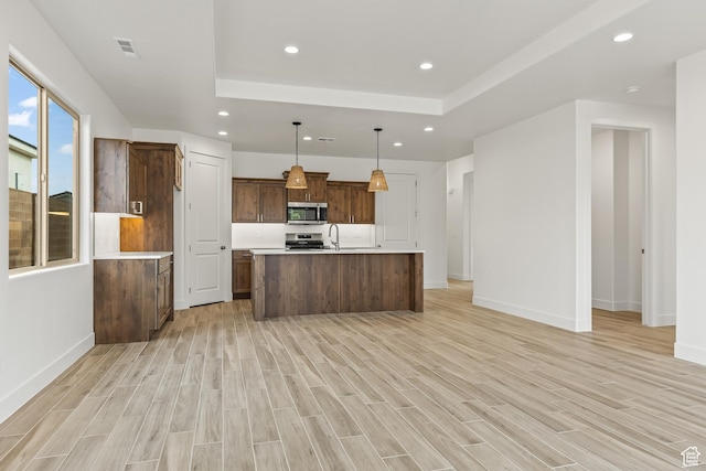 3594 W 185 N, Hurricane, UT 84737 - kitchen featuring decorative light fixtures, stove, light wood-type flooring, and a kitchen island with sink