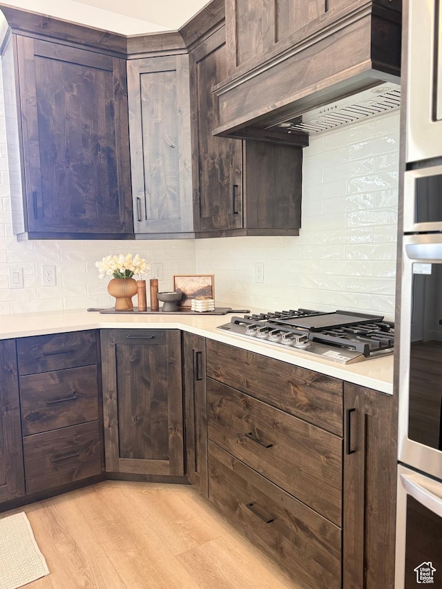 1520 E Parker Ln Unit 422, Lake Point, UT 84074 - kitchen with custom range hood, decorative backsplash, appliances with stainless steel finishes, and light countertops