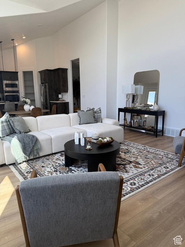 1520 E Parker Ln Unit 422, Lake Point, UT 84074 - living area featuring visible vents, wood finished floors, and high vaulted ceiling