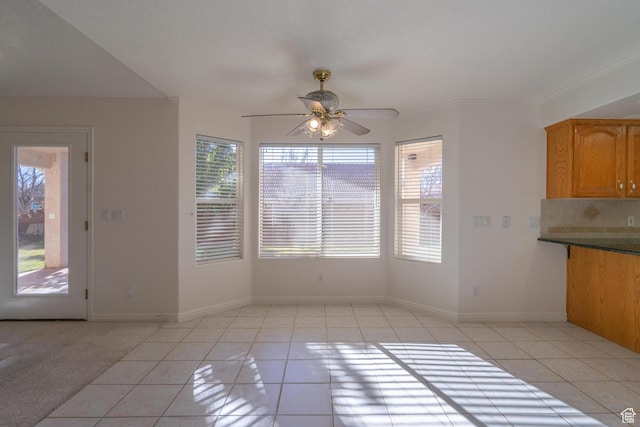 3423 Red Butte Dr, Santa Clara, UT 84765 - unfurnished dining area featuring light tile patterned flooring, baseboards, crown molding, and a ceiling fan