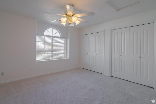 3423 Red Butte Dr, Santa Clara, UT 84765 - unfurnished bedroom featuring multiple closets, a ceiling fan, baseboards, light colored carpet, and attic access