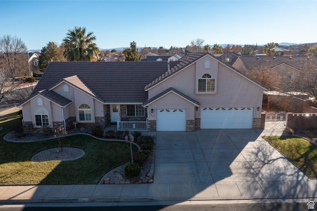 3423 Red Butte Dr, Santa Clara, UT 84765 - view of front facade featuring a tile roof, concrete driveway, stucco siding, stone siding, and a gate