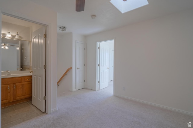 3423 Red Butte Dr, Santa Clara, UT 84765 - interior space with baseboards, a skylight, a sink, light carpet, and connected bathroom