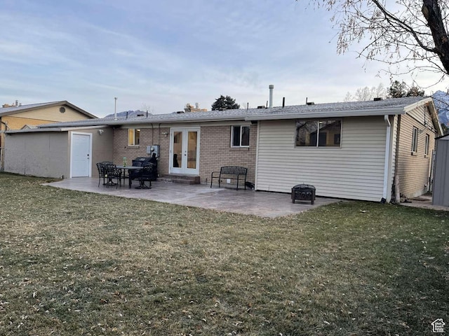 back of property featuring a yard, a patio, and french doors