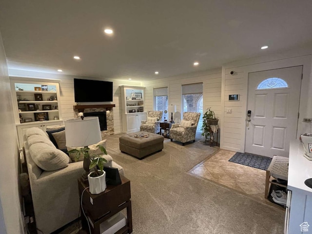living room featuring carpet, built in features, and wood walls
