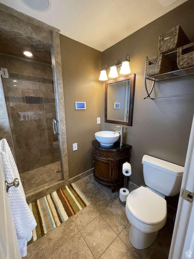 bathroom with tile patterned floors, vanity, toilet, and a shower with shower door