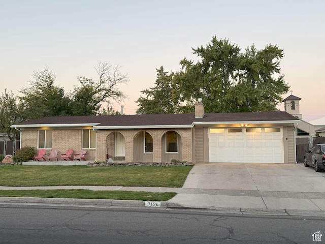 ranch-style house featuring a lawn and a garage