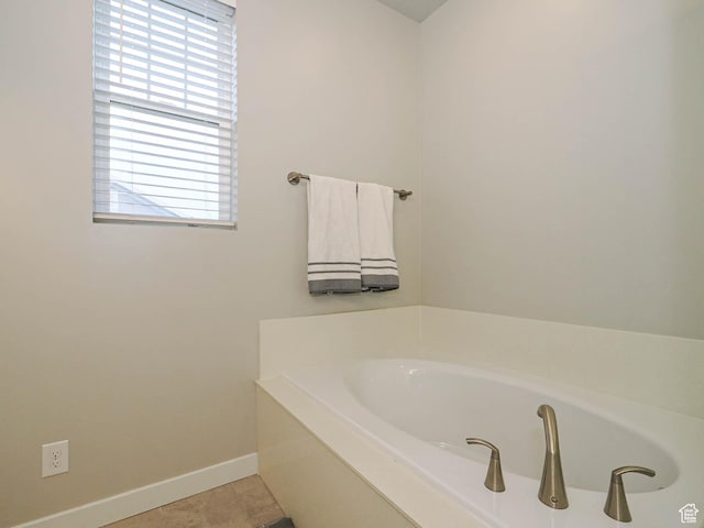 full bathroom featuring tile patterned floors, baseboards, and a garden tub
