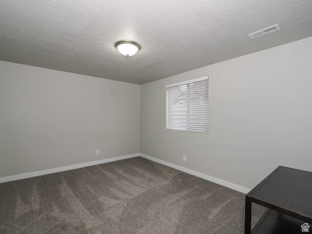 unfurnished room featuring a textured ceiling, carpet flooring, baseboards, and visible vents