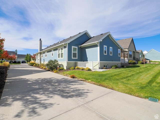 view of property exterior with driveway, a residential view, and a lawn