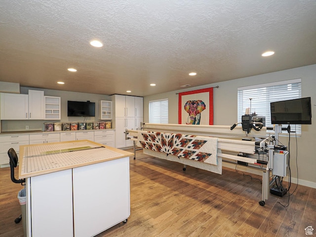 kitchen featuring a textured ceiling, white cabinets, and a kitchen island