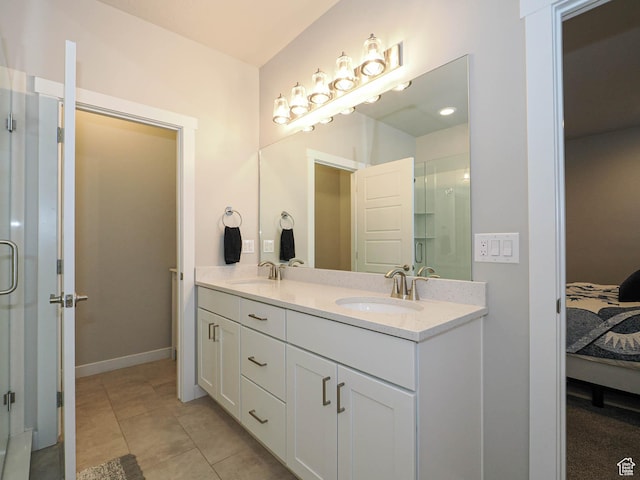 ensuite bathroom featuring a stall shower, tile patterned floors, a sink, and connected bathroom