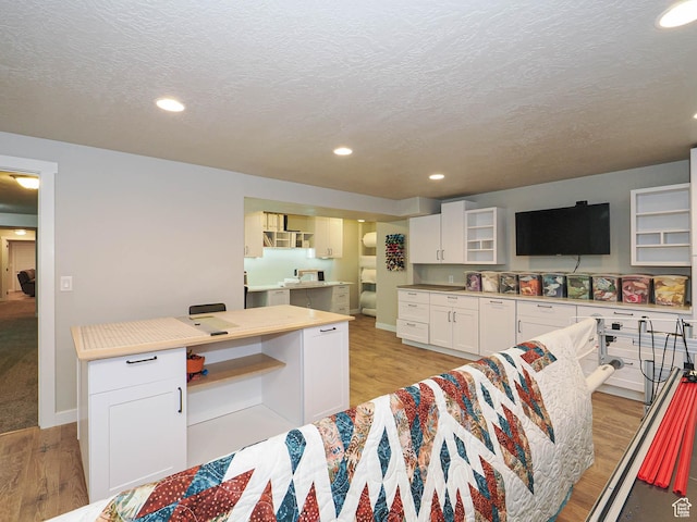 kitchen featuring white cabinets, recessed lighting, light wood-type flooring, and a textured ceiling