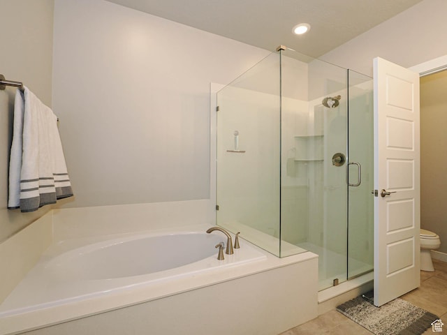 bathroom with tile patterned flooring, toilet, a stall shower, and a garden tub