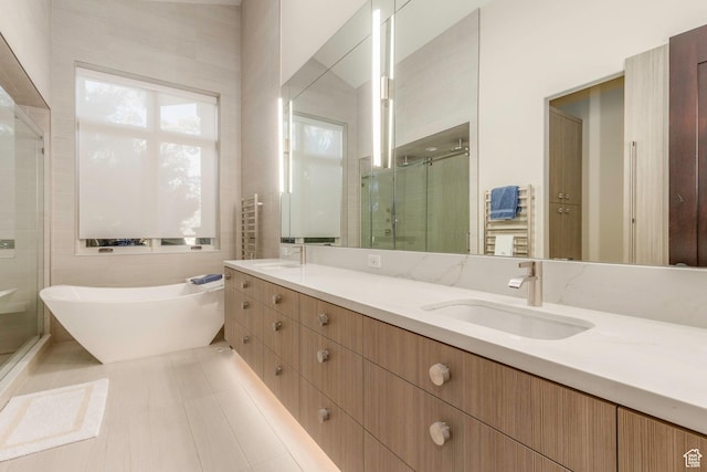 full bathroom with a sink, a shower stall, a freestanding tub, and double vanity