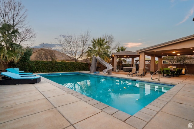 2468 S Dorothy St, Hurricane, UT 84737 - pool at dusk featuring a mountain view, a patio, and a water slide
