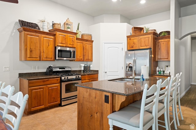 2468 S Dorothy St, Hurricane, UT 84737 - kitchen featuring a center island with sink, sink, a breakfast bar area, dark stone countertops, and stainless steel appliances