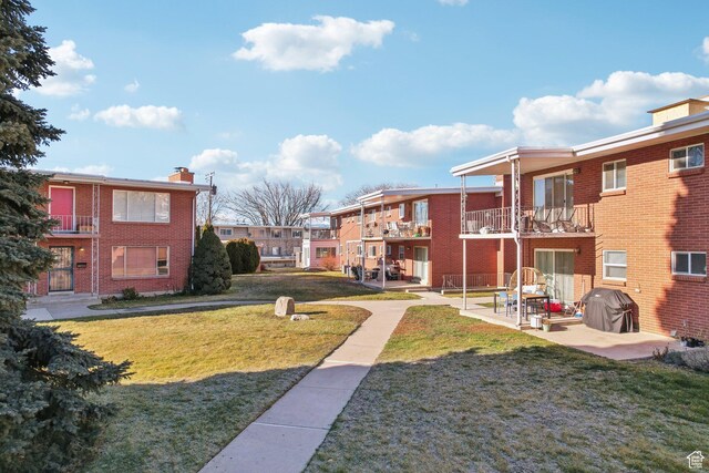 view of home's community with a patio area and a lawn