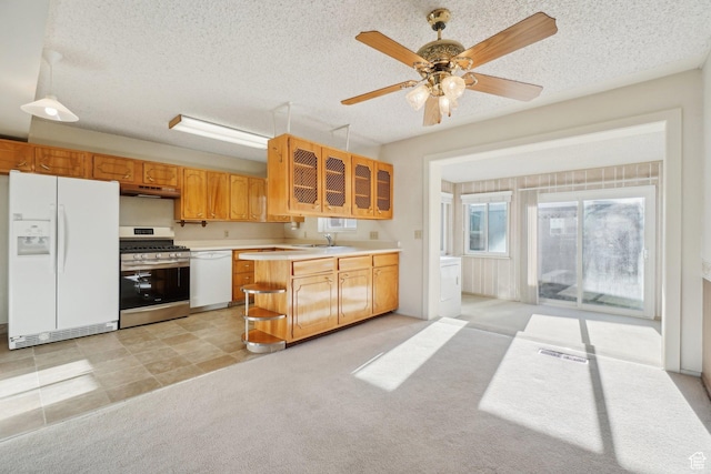 kitchen featuring ceiling fan, sink, light carpet, and white appliances