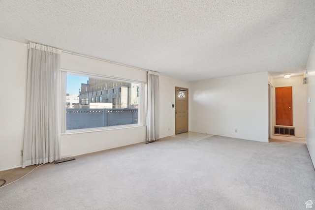 spare room with a textured ceiling and carpet floors