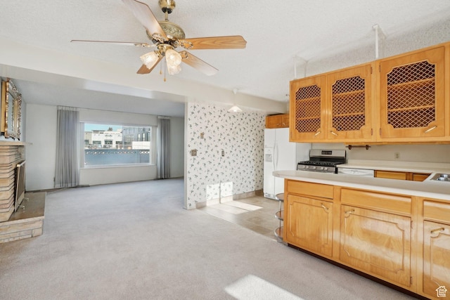 kitchen with white appliances, light carpet, ceiling fan, a textured ceiling, and light brown cabinetry