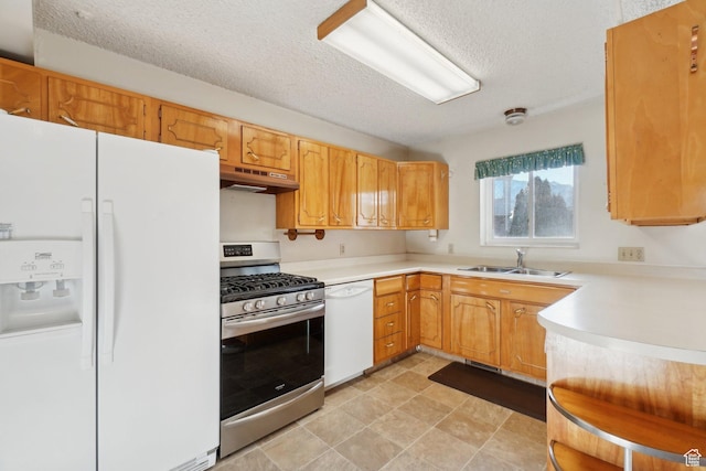 kitchen featuring a textured ceiling, white appliances, and sink