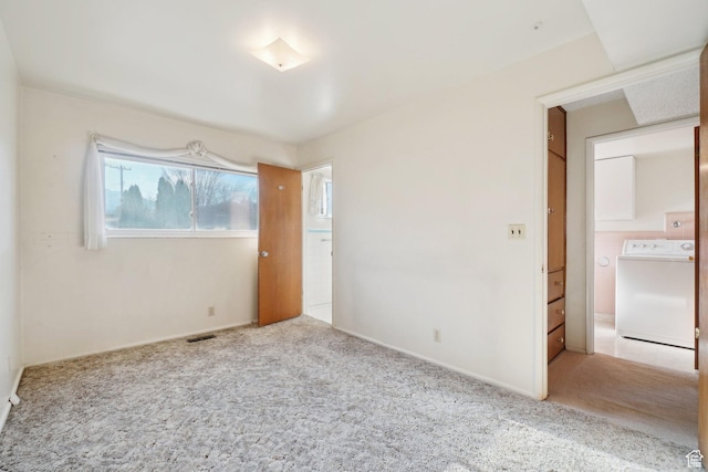 carpeted spare room with washer / clothes dryer