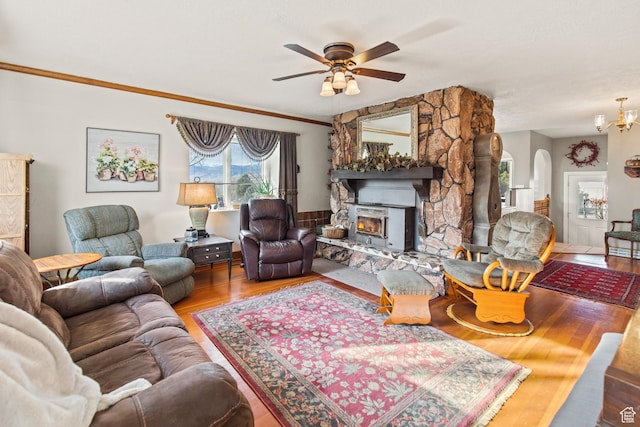 110 N 400 E, Glenwood, UT 84730 - living room featuring wood finished floors, a ceiling fan, arched walkways, a stone fireplace, and a chandelier