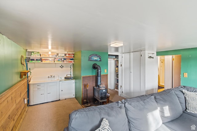 110 N 400 E, Glenwood, UT 84730 - carpeted living area with a wood stove, washing machine and clothes dryer, and wooden walls