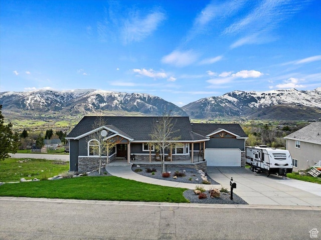 view of front of house featuring a mountain view, a porch, and a garage