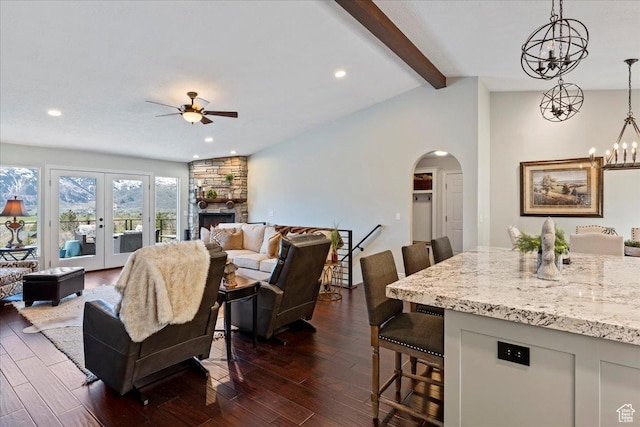 4147 N Wolf Ridge Cir, Eden, UT 84310 - living room with french doors, dark hardwood / wood-style flooring, lofted ceiling with beams, a fireplace, and ceiling fan with notable chandelier
