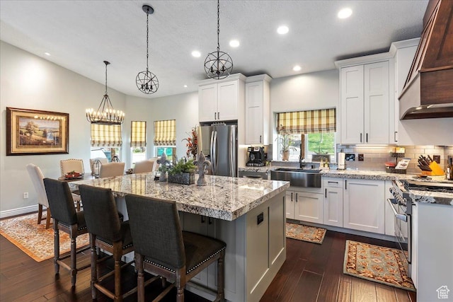 4147 N Wolf Ridge Cir, Eden, UT 84310 - kitchen with white cabinets, sink, hanging light fixtures, a kitchen island, and stainless steel appliances