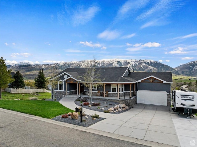 4147 N Wolf Ridge Cir, Eden, UT 84310 - view of front facade featuring a mountain view, a porch, a garage, and a front lawn