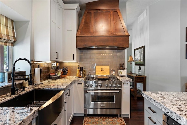 4147 N Wolf Ridge Cir, Eden, UT 84310 - kitchen with custom exhaust hood, high end range, sink, light stone countertops, and white cabinetry