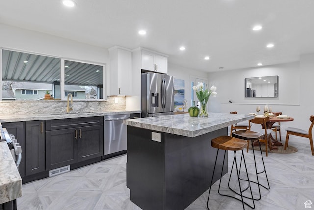 1578 E Delaware Ln S, Holladay, UT 84117 - kitchen featuring light stone countertops, appliances with stainless steel finishes, sink, white cabinets, and light parquet flooring
