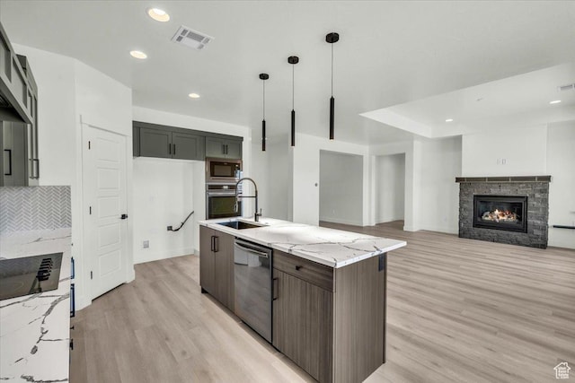 6148 S Square Top Ln, St George, UT 84790 - kitchen with appliances with stainless steel finishes, light stone counters, sink, decorative light fixtures, and a fireplace
