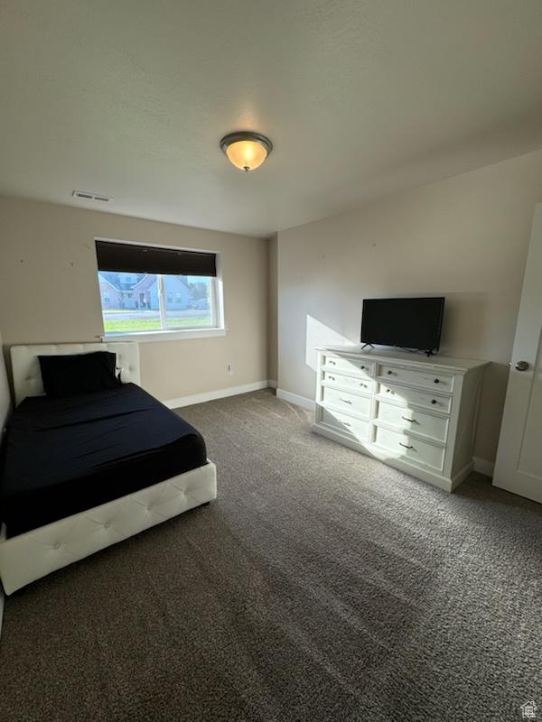 unfurnished bedroom with dark colored carpet