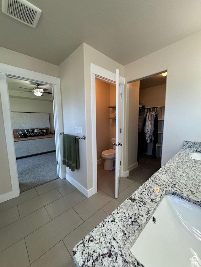 bathroom with tile patterned floors, vanity, toilet, and ceiling fan