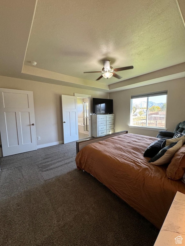 bedroom featuring carpet flooring, a textured ceiling, a raised ceiling, and ceiling fan