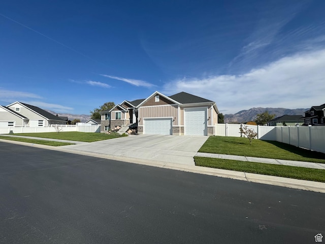 view of front of property featuring a mountain view, a front yard, and a garage
