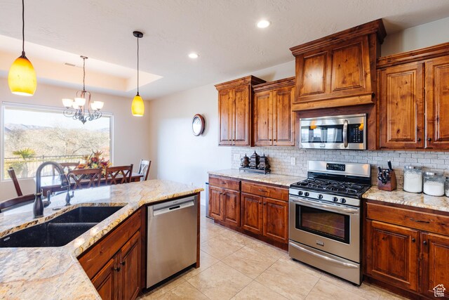 437 N Northstar Dr, St George, UT 84770 - kitchen with appliances with stainless steel finishes, decorative light fixtures, sink, light stone counters, and a tray ceiling