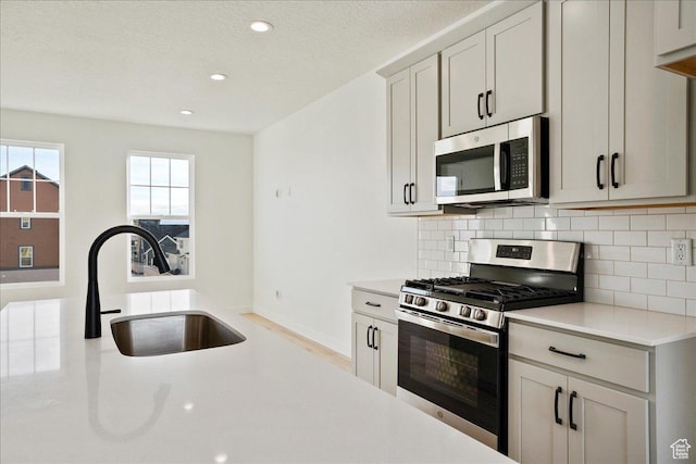 7029 W S Jordan Pkwy Unit 380, South Jordan, UT 84009 - kitchen featuring appliances with stainless steel finishes, a sink, light countertops, backsplash, and recessed lighting