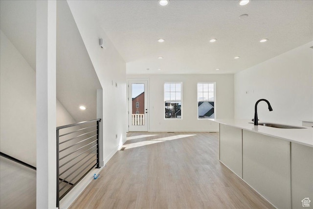 7029 W S Jordan Pkwy Unit 380, South Jordan, UT 84009 - corridor with a sink, light wood-type flooring, an upstairs landing, recessed lighting, and a textured ceiling