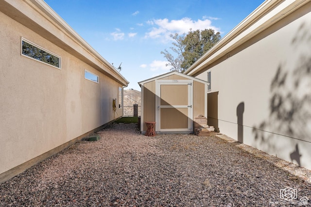 view of yard featuring a shed, fence, and an outdoor structure