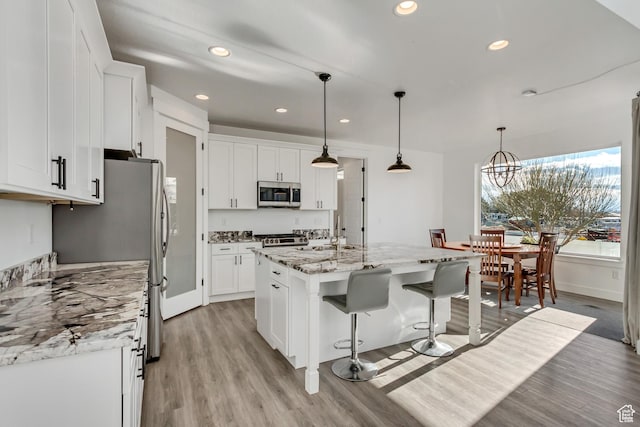 1153 W 1425th Dr N, Lehi, UT 84043 - kitchen featuring pendant lighting, white cabinets, light stone countertops, an island with sink, and appliances with stainless steel finishes