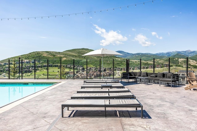 view of swimming pool with a mountain view and a patio area