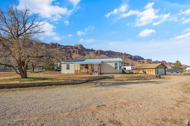 ranch-style home with a mountain view and solar panels